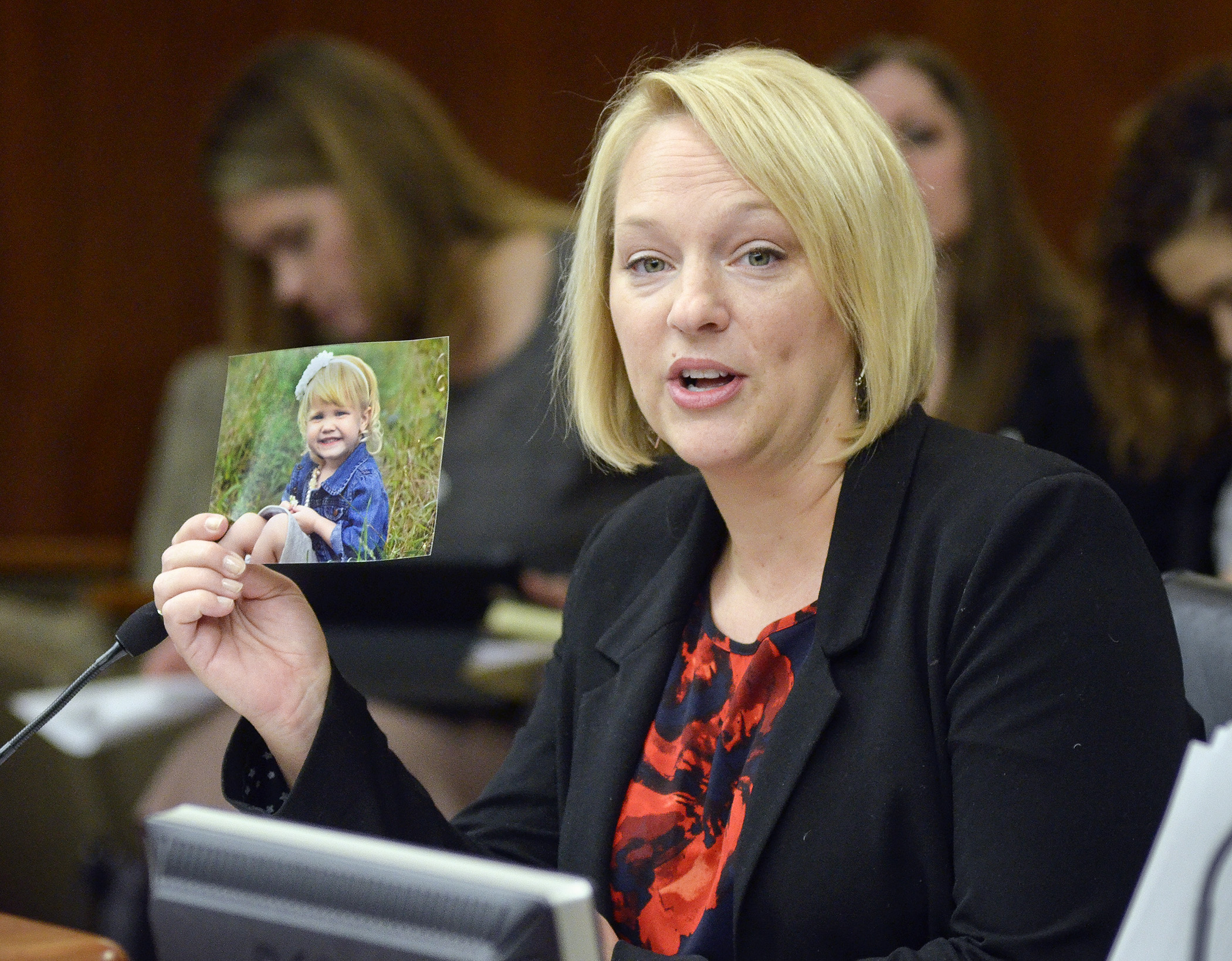 Nicole Monacell, who used the services of a surrogate mother, displays a photo of Payton Cecelia Monacell while testifying before the House Civil Law and Data Practices Committee March 5 in opposition to a bill that would establish a Legislative Surrogacy Commission. Photo by Andrew VonBank